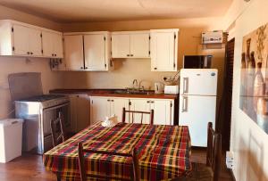 格罗斯岛NEW- Rodney Bay two bedrooms BEST VIEW 6的厨房配有白色橱柜和带拼盘桌布的桌子。