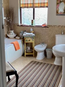 大莫尔文Orchard Side Bed and Breakfast的带浴缸、卫生间和盥洗盆的浴室
