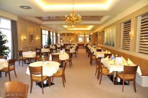 巴特圣莱昂哈德艾格森德巴德圣里奥纳德酒店的餐厅配有白色的桌椅和吊灯