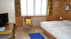 采尔马特Hotel Alpina的一间卧室配有一张床和一张带黄色枕头的书桌