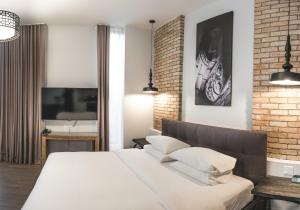 三河城Hotel Oui GO!的卧室配有白色的床和砖墙