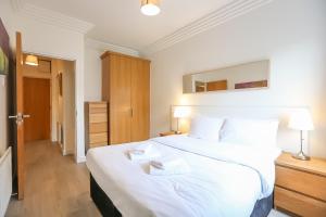 都柏林IFSC Townhouse Apartments的一间卧室配有一张带白色床单的大床