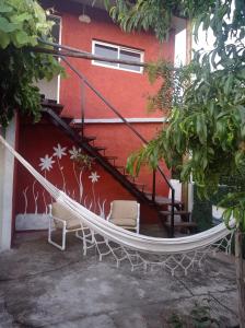 米纳斯Hosteling Las Margaritas的一座带红墙的建筑外的吊床
