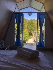 布罗莫布罗莫营地之家的一张位于带蓝色窗帘窗户的房间里的床