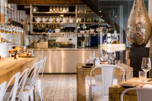 马斯特里赫特Boatlodge Antigua的餐厅设有酒吧,配有白色的桌椅