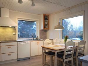 SvanesundThree-Bedroom Holiday home in Svanesund 3的一间带木桌的厨房和一间餐厅