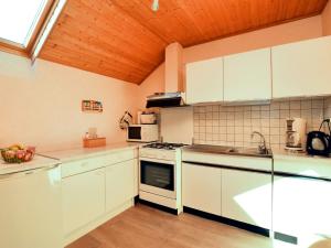 NidrumBeautiful Apartment near Forest in Nidrum的一间厨房,配有白色家电和木制天花板
