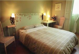 塞哥维亚福尔诺斯旅馆的一间卧室配有一张大床和两把椅子
