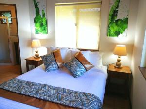 维拉港泻湖上的罂粟酒店的一间卧室配有一张带枕头的床和两盏灯。
