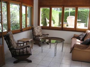巴古尔Belvilla by OYO La Pineda的客厅配有椅子和桌子,设有窗户