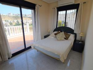 罗哈莱斯Belvilla by OYO Marquesa View的一间卧室设有一张床和一个大窗户