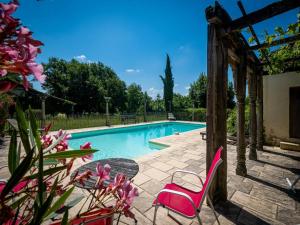 Le HougaBeautiful farmhouse with private pool的游泳池设有两把粉红色的椅子和鲜花
