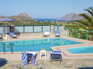 莱弗考基亚Chic Villa in Lefkogia Crete with Swimming Pool的一个带蓝白椅子的游泳池以及大海