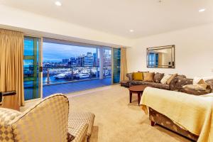 奥克兰QV Private Waterfront Apartment - Princes Wharf - 379的带沙发和大窗户的客厅