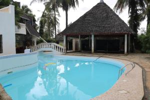 蒙巴萨Room in Guest room - A wonderful Beach property in Diani Beach Kenya的一个带凉亭的大型蓝色游泳池