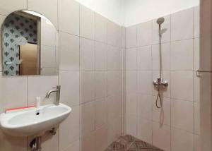 Pulauberayan DadapRedDoorz Plus @ Jalan Letda Sujono Medan 2的白色的浴室设有水槽和镜子
