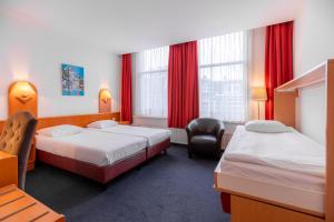 阿姆斯特丹猫头鹰酒店的酒店客房,配有两张床和椅子
