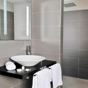 利伯维尔ONOMO Hotel Libreville的一间带水槽和镜子的浴室