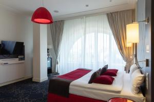 顿河畔罗斯托夫顿河畔罗斯托夫中心美居酒店的酒店客房配有一张带红色枕头的大床