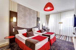 顿河畔罗斯托夫顿河畔罗斯托夫中心美居酒店的酒店客房,设有两张床和红灯