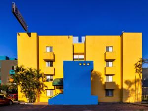 瓜达拉哈拉Suites Navata的前面有蓝色物体的黄色建筑