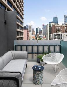 墨尔本Lancemore Crossley St. Melbourne的屋顶庭院配有沙发和桌子。