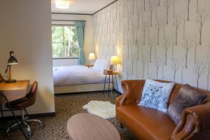 白马村Maple Chalet Hakuba的酒店客房设有一张沙发和一张床