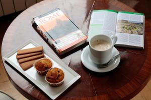 罗马艺术酒店的桌子,书,咖啡和松饼