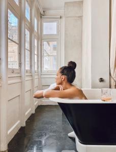 瓦莱塔Casa Ellul - Small Luxury Hotels of the World的坐在浴室浴缸里的女人