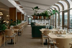 赫尔辛基赫尔辛基苏可酒店的餐厅设有桌椅和窗户。