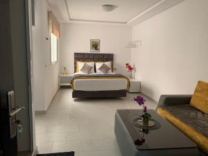 丹吉尔Appart Hotel Monaco的酒店客房,配有床和沙发