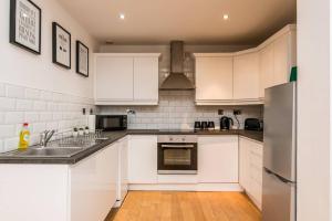 利物浦Host & Stay - Exchange Quarters的厨房配有白色橱柜和不锈钢冰箱
