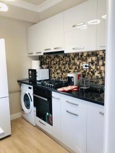 BuzăuThe Classic Studio的厨房配有白色橱柜、洗衣机和烘干机
