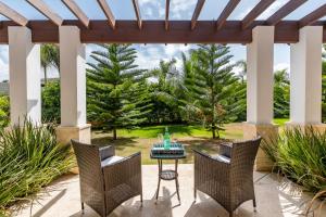 拉罗马纳Stunning Villa with Private Pool and Jacuzzi in Casa de Campo的凉亭下带桌椅的天井