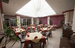 莫纳斯提尔自由度假酒店的一间带桌椅和白色大天花板的餐厅
