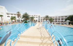 莫纳斯提尔自由度假酒店的度假村旁的游泳池,带蓝色椅子
