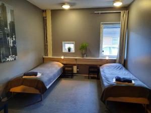 乌普萨拉Vandrarhem Uppsala - Portalgatan的一间卧室设有两张床、一张桌子和一个窗口。