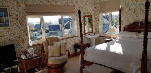 滕比威奇伍德宾馆的一间卧室配有一张床、一把椅子和窗户。