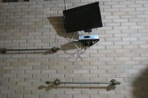 特林达德Pousada Mar Azul的砖墙上的电视,带摄像头