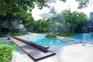 七岩Baan San Kraam 5206 Cha-am Hau Hin的度假村内带长凳的游泳池