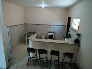 TamoiosCasa em Unamar 3 Cabo Frio RJ的一间厨房,内设一个柜台和四把凳子