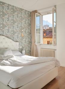 特伦托Lainez Rooms & Suites的卧室配有白色的床和窗户。