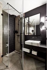 华沙Crowne Plaza - Warsaw - The HUB, an IHG Hotel的一间带水槽和玻璃淋浴的浴室