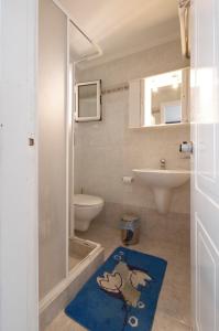 爱琴娜岛克隆酒店 - 克隆基里亚科斯的浴室配有卫生间、水槽和蓝色地毯。