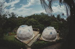 伊利亚贝拉Hostel Da Vila Ilhabela的两顶帐篷,位于庭院的甲板上