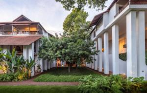 清迈拉雅文化酒店- SHA Plus的庭院内树木的建筑的外部景色