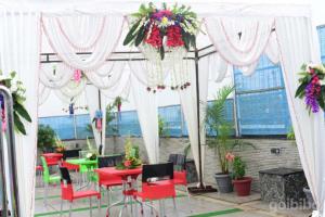丹巴德Hotel Madhuvan by TravelkartOnline的白色天篷下的庭院配有红色的桌椅