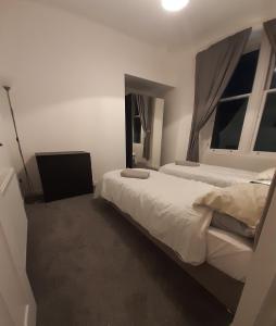 邓弗姆林Carvetii - Edward House A - 2 Dbl bed 1st floor flat的一间卧室设有两张床和两个窗户。