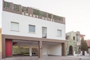 蒙特雷Smart Hotel Monterrey的一座白色的大建筑,上面标有读懂智能酒店的标志