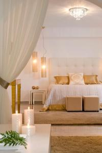易莫洛林大都会套房酒店 - 世界小型豪华酒店集团的一间白色卧室,配有一张带两个蜡烛的床